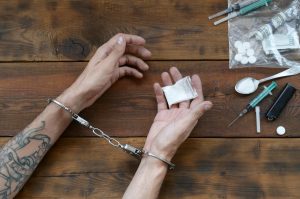 Drug traffickers were arrested along with their heroin. Police arrest drug dealer with handcuffs. Law and police concept for world anti drug day. 26 June, International day against drug abuse.